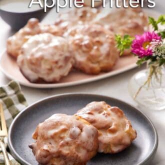 Pinterest graphic of a plate with two pieces of air fryer apple fritters. More fitters on a platter in the background.