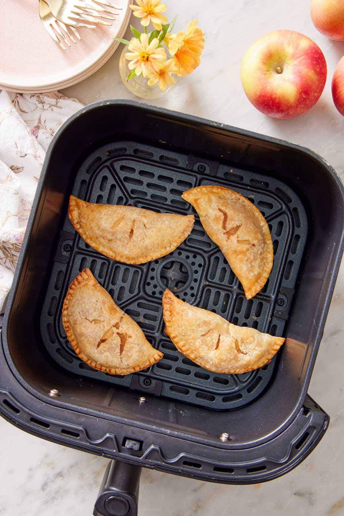 Overhead view of four air fryer hand pies in an air fryer basket.