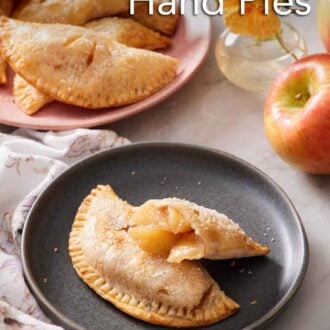 Pinterest graphic of a plate with an air fryer hand pie with a second half leaning on top, showing the interior. More hand pies in the background.