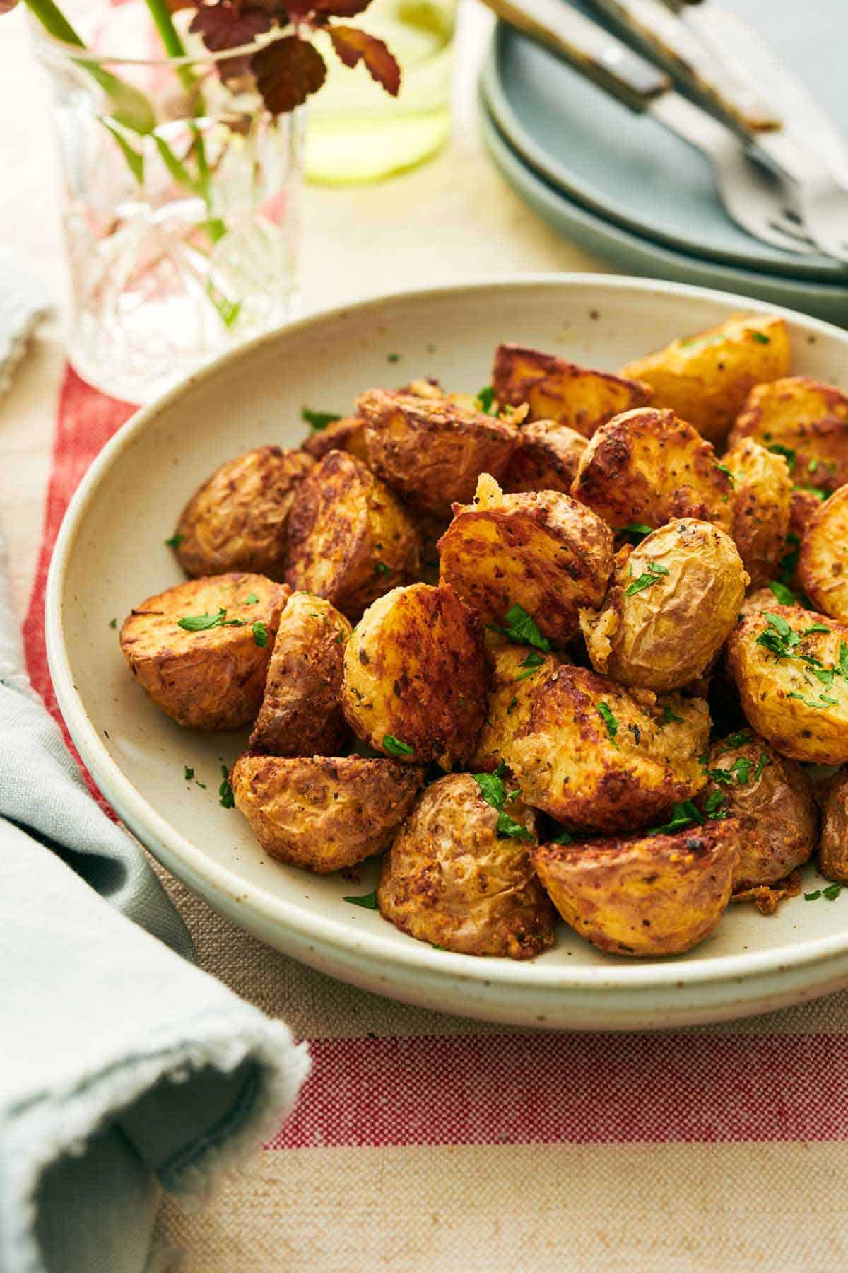 A plate of crispy air fryer potatoes topped with chopped parsley.