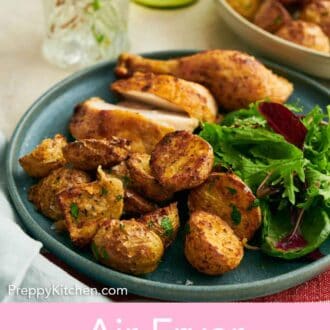 Pinterest graphic of a plate of air fryer potatoes, salad, and chicken with a close up on the potatoes.