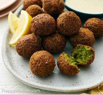 Pinterest graphic of a platter with multiple falafel with lemon wedges and a bowl of tahini sauce.