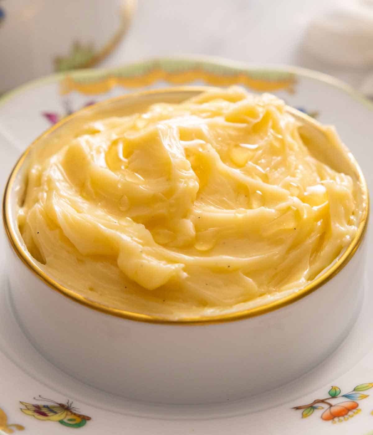 A bowl of creamy honey butter on a plate.