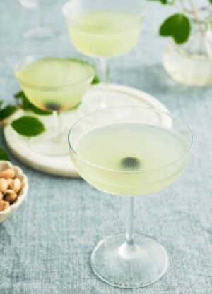 A glass of Last Word Cocktail with two more in the background on a serving platter.