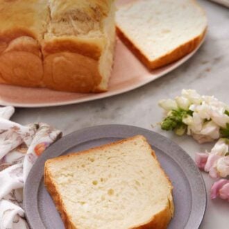 Pinterest graphic of a plate with a slice of milk bread. The rest of the loaf in the back on a platter with one slice cut.