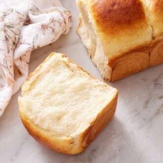 A third of a loaf of milk bread torn in front of the rest of the loaf.