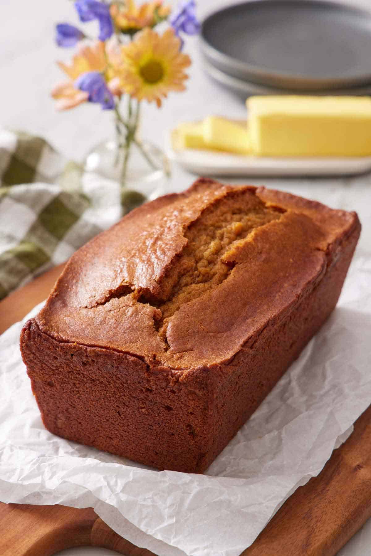 A loaf of pumpkin bread on a parchment-lined cutting board.