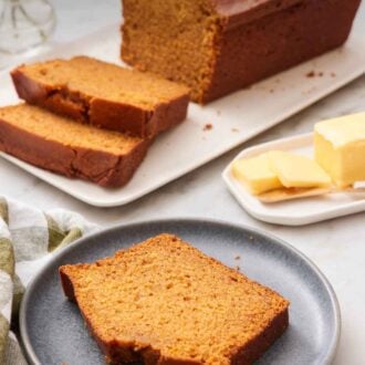 Pinterest graphic of a plate with a slice of pumpkin bread. A loaf in the background with two slices cut in from to fit.