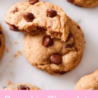 Pinterest graphic of two pumpkin chocolate chip cookies, one on placed on top, half eaten.