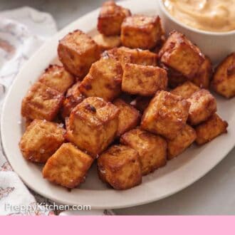 Pinterest graphic of a platter of crispy air fryer tofu with a bowl of dip.