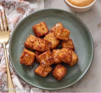 Pinterest graphic of a green plate of air fryer tofu with a bowl of dipping sauce on the side.