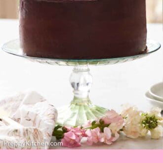 Pinterest graphic of a cake stand holding a Ding Dong cake. A linen napkin and flowers in front.