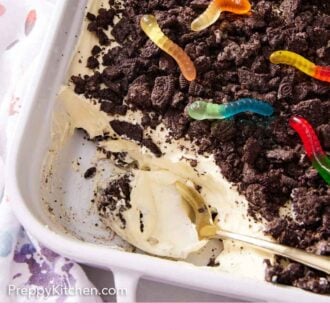 Pinterest graphic of a spoon inside of the baking dish of dirt cake.