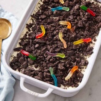 Overhead view of dirt cake in a baking dish with a serving spoon on the side.