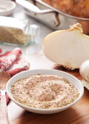 A bowl of turkey seasoning with roasted turkey ingredients in the background.
