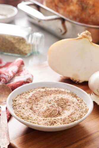 A bowl of turkey seasoning with roasted turkey ingredients in the background.