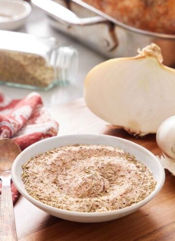 A bowl of turkey seasoning with roasted turkey ingredients in the background.