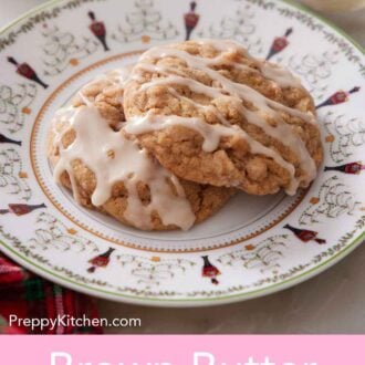 Pinterest graphic of a plate with two brown butter wassail cookies with icing drizzled on top.