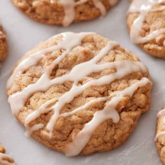 A close up view of brown butter wassail cookies with icing drizzled on top.