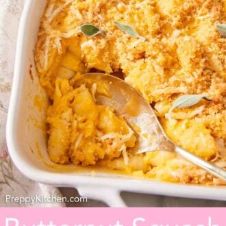 Pinterest graphic of a close up view of a baking dish of butternut squash mac and cheese with a serving spoon.