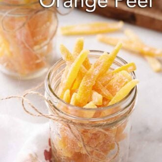 Pinterest graphic of a mason jar full of candied orange peels. A second jar in the background.