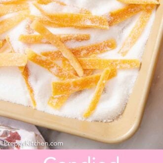 Pinterest graphic of a close up view of candied orange peels in a sheet pan of sugar.