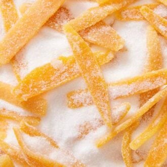 A close up view of candied orange peel in sugar.