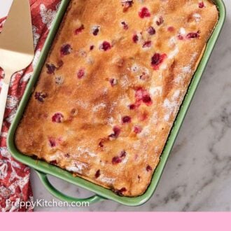 Pinterest graphic of a green baking dish containing a cranberry cake.