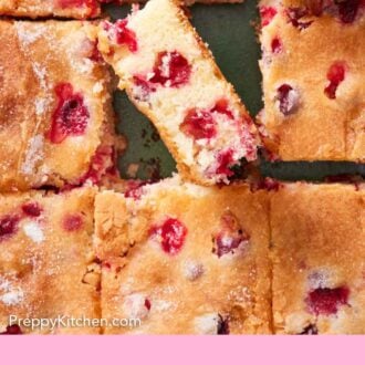 Pinterest graphic of an overhead view of a cranberry cake cut into squares and the middle piece flipped up to see the interior.