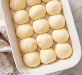 Pinterest graphic of proofed dinner roll dough balls in a white baking dish.