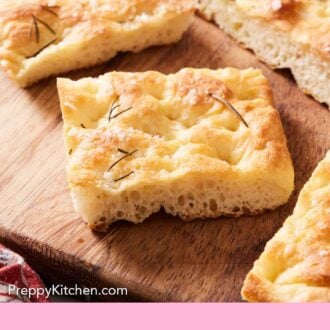 Pinterest graphic of focaccia cut on a wooden cutting board.