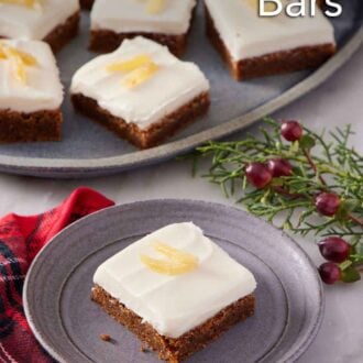 Pinterest graphic of a plate with a gingerbread bar topped with candied ginger. A platter in the background with additional bars.