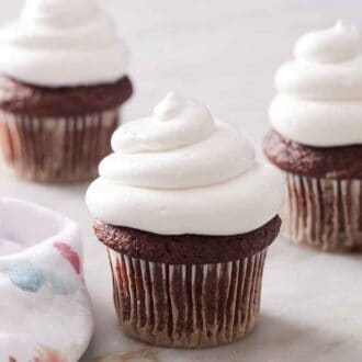 Three chocolate cupcakes topped with marshmallow frosting.