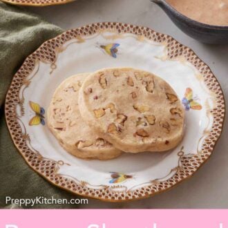 Pinterest graphic of a plate with two pecan shortbread cookies with a bowl of glaze on the side.