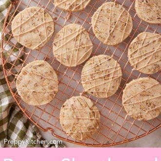 Pinterest graphic of pecan shortbread cookies with glaze drizzled on top on a round cooling rack.