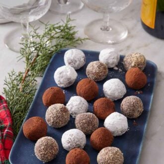 Pinterest graphic of a blue platter of rum balls with various coatings.