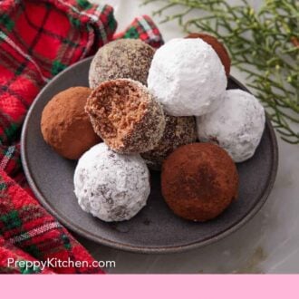 Pinterest graphic of a plate with a pile of rum balls with one with a bite taken out of it.