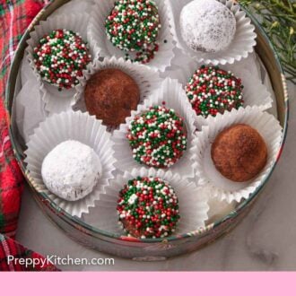 Pinterest graphic of a round tin with rum balls in individual paper liners.