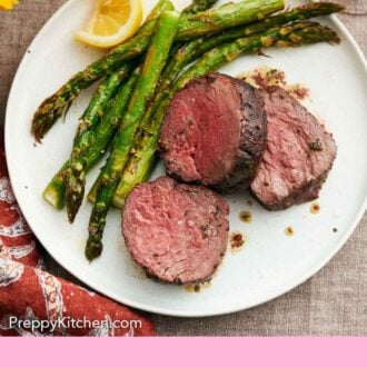 Pinterest graphic of a plate with three pieces of beef tenderloin with roasted asparagus along with a lemon wedge.