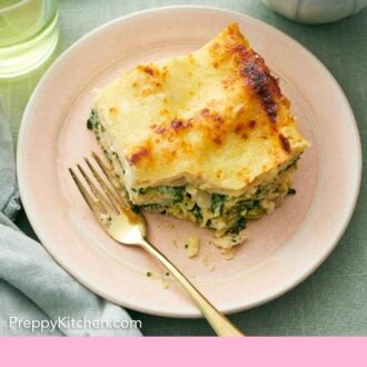 Pinterest graphic of an overhead view of a slice of chicken lasagna with a bite taken out.