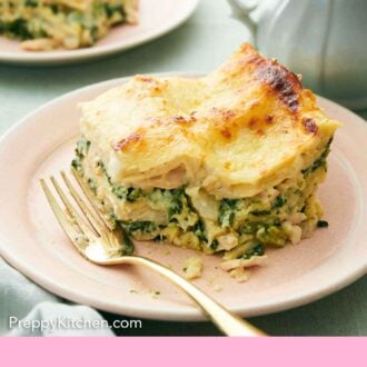 Pinterest graphic of a slice of chicken lasagna with a bite taken out with a fork beside it.