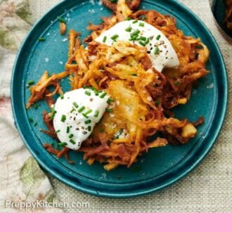 Pinterest graphic of a blue plate with two potato latkes topped with sour cream, chives, and pepper.