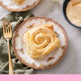 Pinterest graphic of an overhead view of plated orange rolls with a bowl of glaze on the side.