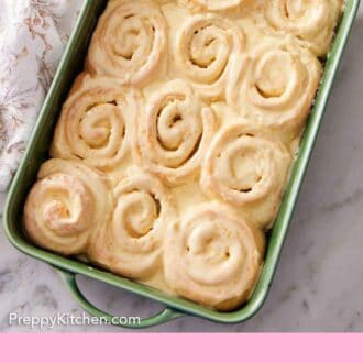 Pinterest graphic of glazed orange rolls in a green baking dish.