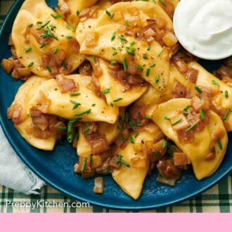 Pinterest graphic of a platter of pierogies topped with chives with a small bowl of sour cream on the side.