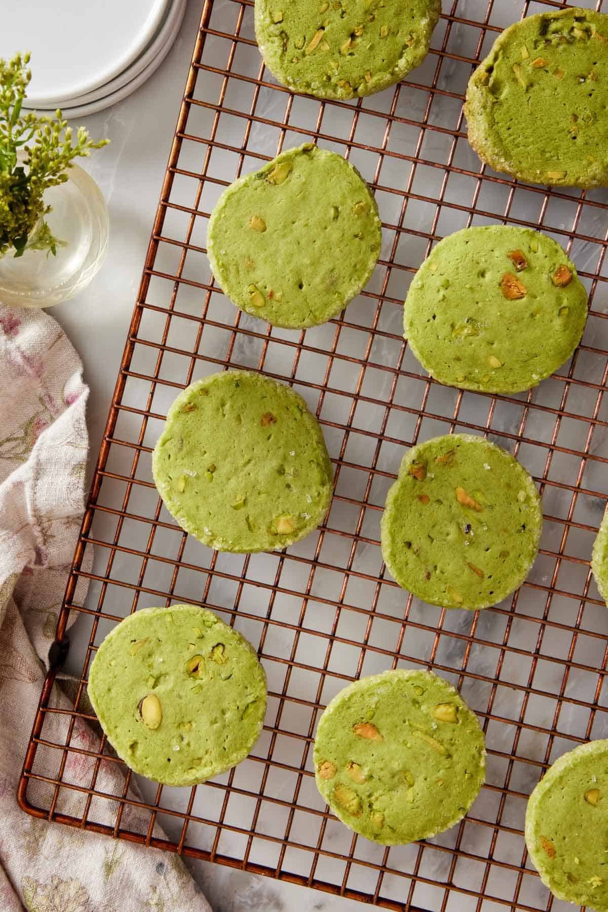 Overhead view of pistachio matcha cookies on a wire cooling rack.