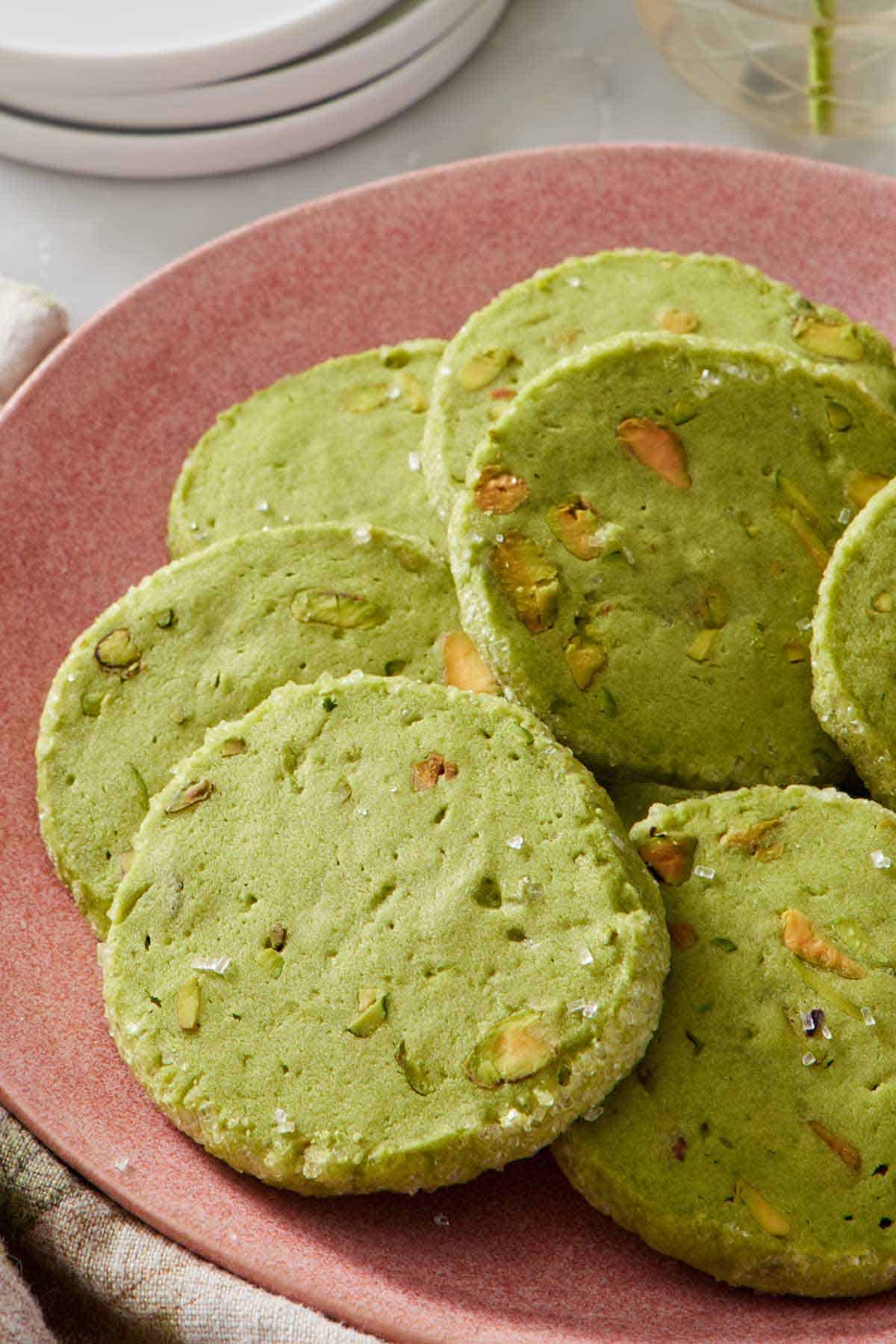 A close up view of a pink plate of pistachio matcha cookies.