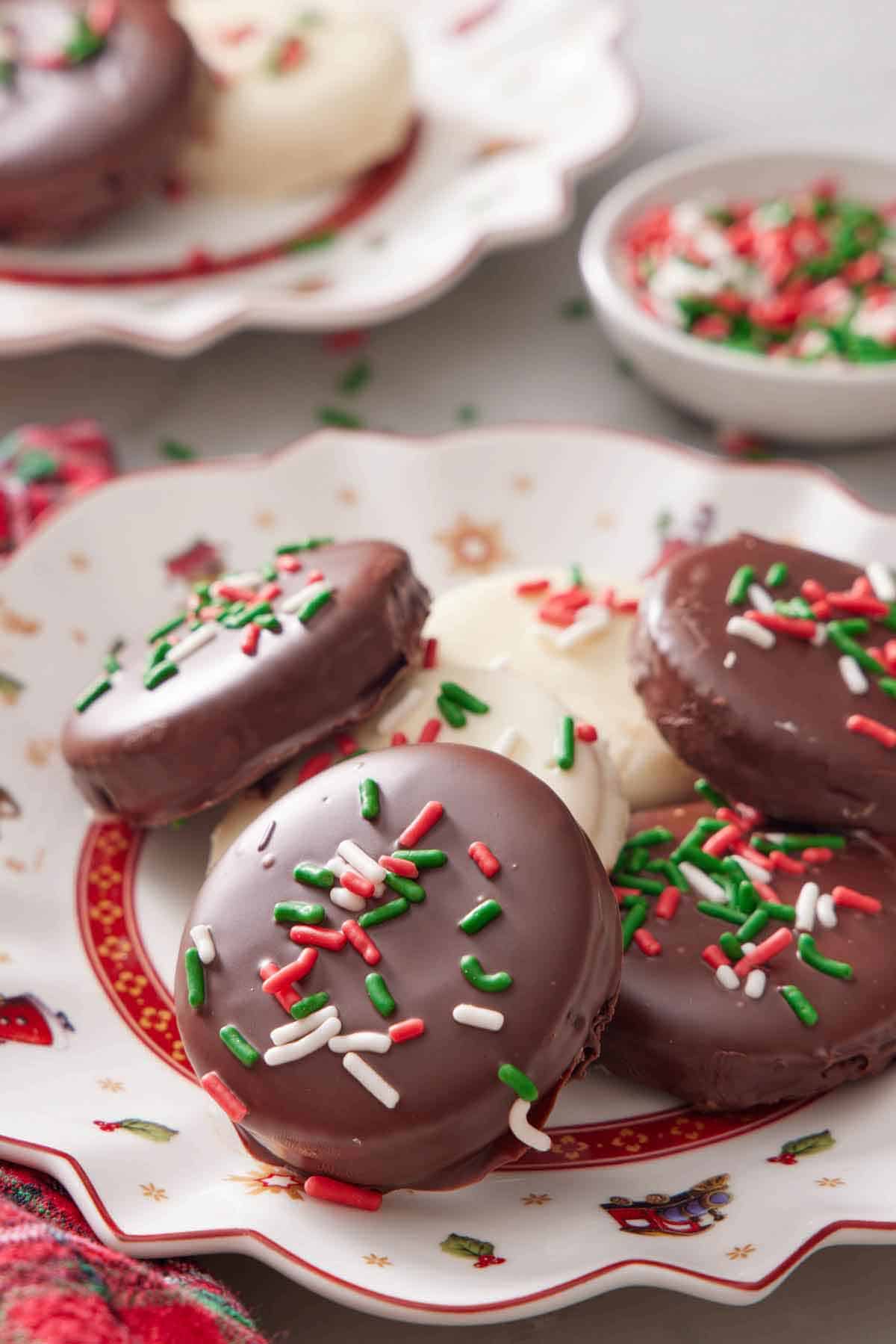 A platter of Ritz cookies with festive sprinkles, half coated with dark chocolate and half coated in white chocolate.