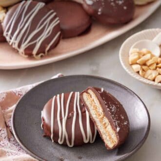 Pinterest graphic of a plate with a Ritz cookie with a cut half leaning on top of it. A platter with more Ritz cookies in the background.