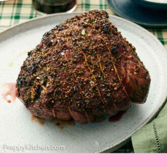 Pinterest graphic of a roast beef on an oval platter with a bowl of horseradish sauce in the back.